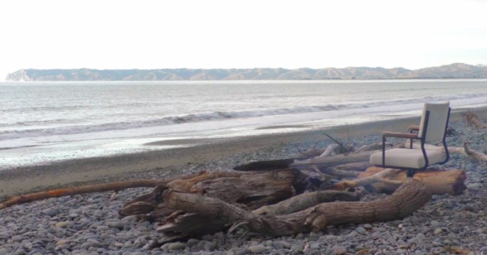 still from video showing empty beach and chair